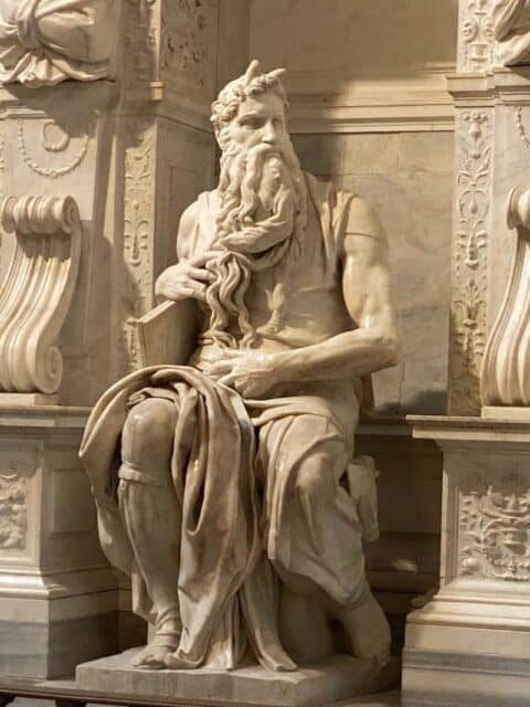 stone statue of moses sitting on a chair